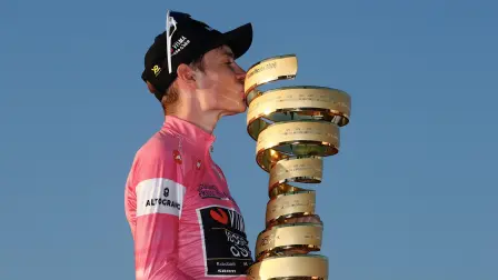 El ciclista danés Jonas Vingegaard, del equipo Visma Lease a Bike, con el maillot rosa de líder de la clasificación general, besa el trofeo mientras celebra en el podio tras ganar el Giro de Italia 2026.