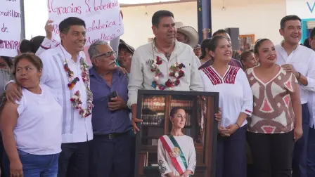 Joel Bravo, al centro, con el retrato de la presidenta Claudia Sheinbaum.