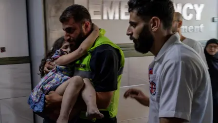 Un miembro de la defensa civil lleva en brazos a una niña herida tras un ataque israelí en Barish, a su llegada al hospital Jabal Amel en Tiro.