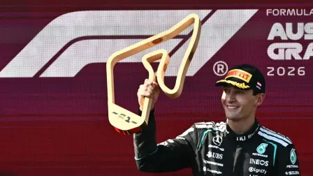 Winner Mercedes' British driver George Russell celebrates on the podium with the trophy after the Formula One Austrian Grand Prix at the Red Bull Ring race track in Spielberg, Austria on June 28, 2026. (Photo by Joe Klamar / AFP)