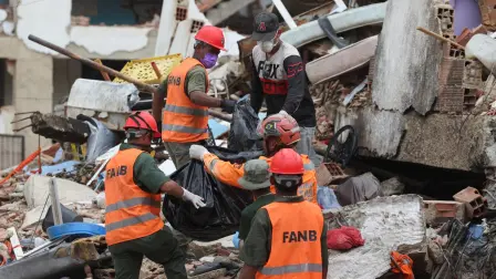 Equipos de rescate recuperan un cuerpo de entre los escombros de un edificio derrumbado tras los sismos gemelos del 24 de junio en La Guaira, Venezuela.