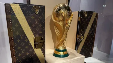 Réplica del trofeo de la Copa Mundial exhibida en un baúl para trofeos de Louis Vuitton.