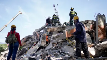Equipos de rescate trabajan entre los escombros del edificio Torres de Limonar tras un terremoto, en Cali, Colombia.