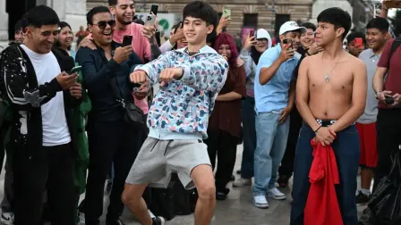 Two young Mexicans gesture toward their opponent during a face-off in the so-called "Aura Battle" in Mexico City on August 20, 2026. The so-called "Aura Battle" is a new viral trend among young people in which two individuals face off in public spaces without speaking, using poses, walks, or dance moves to demonstrate who projects more charisma and style. (Photo by Yuri CORTEZ / AFP)