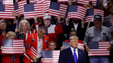 El presidente de Estados Unidos, Donald Trump, observa mientras los asistentes sostienen carteles con la bandera estadounidense en la Convención Nacional Republicana de mitad de mandato en Dallas, Texas, realizada el 9 de septiembre de 2026.