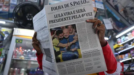 Una mujer lee un periódico cuya portada anuncia la victoria del presidente de Brasil y candidato a la reelección, Luiz Inácio Lula da Silva, un día después de la segunda vuelta de las elecciones presidenciales en São Paulo, Brasil, el 26 de octubre de 2026.