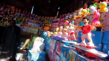 A seller waits for the customers near the toys depicting Liverpool