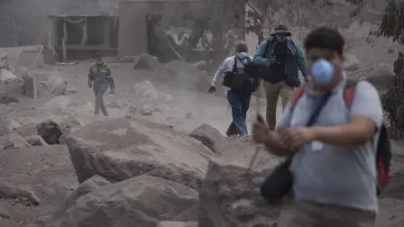 Journalist leave the disaster zone after an alert near the Volcan de Fuego, or "Volcano of Fire," in Escuintla, Guatemala, Tuesday, June 5, 2018. The fiery volcanic eruption in south-central Guatemala killed scores as rescuers struggled to reach people where homes and roads were charred and blanketed with ash. (AP Photo/Moises Castillo)
