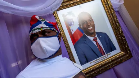 Un joven carga un retrato del difunto presidente Jovenel Moise. Foto: Reuters.