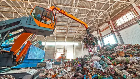 Excavator,Grabs,Trash,In,Warehouse,Of,Waste,Processing,Plant