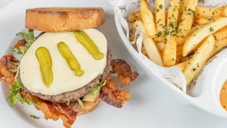 Hambourgeois “Au Pied de Cochon”, pan de caja, tocino crujiente, jitomate y portobello confitados y papas trufadas.