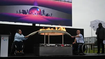 Los británicos Helene Raynsford y Gregor Ewan encienden las antorchas del pebetero durante la ceremonia de encendido de la antorcha paralímpica. Foto: AFP