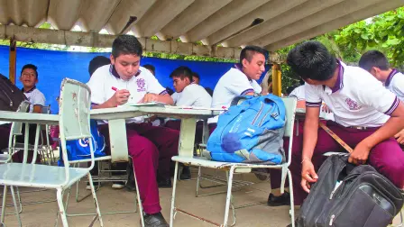 JUCHITÁN, OAXACA, 06SEPTIEMBRE2018.- A casi una año de cumplirse del sismo del 7 de septiembre de 2017, el cual afectó con severidad la zona del Itsmo del estado, aún el día de hoy se observan diversas aulas improvisadas con materiales como laminas, y al aire libre, en donde estudian cientos de alumnos de educación básica. Tan solo en esta zona mas de mil 952 resultaron dañados, muchos de ellos aún con grandes pendientes en su remozamiento. Durante un recorrido por diversos planteles se observa como algunos salones literalmente están amarrados con cuerdas para que las laminas que son sus paredes no se las lleve el viento, otros solo tienen un techo de lamina, mientras que algunos solo cuentan con una lona rota para guarecerse del clima. 
FOTO: F. REYNA LUCERO /CUARTOSCURO.COM