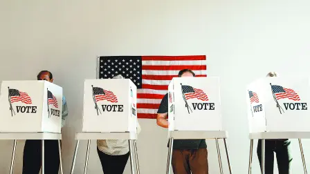 US election day, Diverse people at voting booth at US election station with American flag in background. Diverse people in line to vote at US election day. Vote for American democracy.