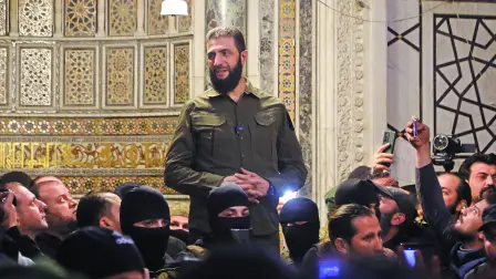 The leader of Syria's Islamist Hayat Tahrir al-Sham (HTS) group that headed a lightning rebel offensive snatching Damascus from government control, Abu Mohammed al-Jolani, addresses a crowd at the capital's landmark Umayyad Mosque on December 8, 2024. - Jolani, now using his real name Ahmed al-Sharaa, gave a speech as the crowd chanted 