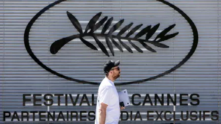 Un peatón pasa junto al logotipo del Festival de Cine de Cannes, en vísperas de la 78ª edición del Festival de Cine de Cannes, en Cannes, sur de Francia.
