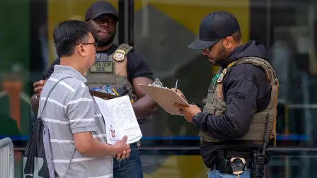 Un agente de ICE interroga a un migrante.