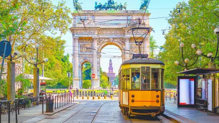 Vista del Arco de la Paz con tranvía amarillo en Milán, Italia. La ciudad con el mayor número de alojamientos certificados con el sello Travel Proud.
