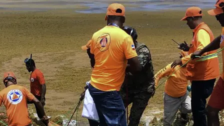 Miembros de la Defensa Civil y la Armada recuperan el cuerpo de un náufrago.