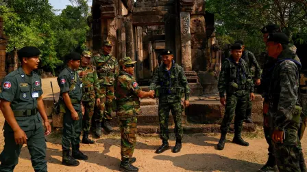 Un soldado camboyano (centro, izq.) estrecha la mano de un soldado tailandés (centro, der.) en el disputado antiguo templo jemer Prasat Ta Muen Thom, en la frontera entre Camboya y Tailandia