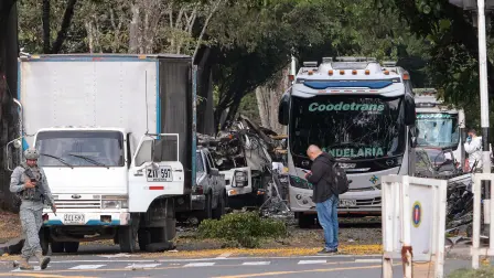 Miembros de las fuerzas de seguridad colombianas inspeccionan el área de la explosión de una bomba en Cali, Colombia.