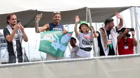 Greta Thunberg y otros activistas saludan mientras su barco zarpa.