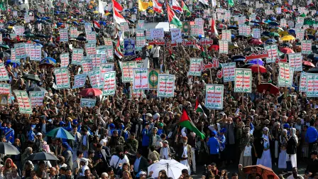 Partidarios de los hutíes de Yemen levantan carteles y banderas mientras se reúnen para celebrar el alto el fuego en la Franja de Gaza, en Saná, el 10 de octubre de 2025.