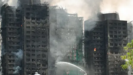 Los bomberos rocían agua sobre las llamas mientras un gran incendio quema varios bloques de apartamentos en el complejo residencial Wang Fuk Court en el distrito Tai Po de Hong Kong
