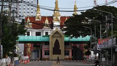 A person walks past the closed Ban Klong Luk border crossing from Thailand to Cambodia, in Aranyaprathet town in the Thai border province of Sa Kaeo on December 12, 2025. (Photo by Lillian SUWANRUMPHA / AFP)