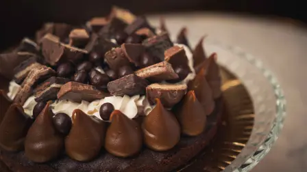 A closeup shot of a tasty chocolate cake on a glass plate on a table
