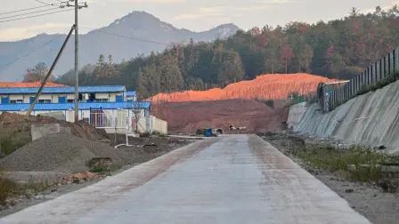 In this photo taken on November 21, 2025, a view of the under-construction Rare Earth Industrial Park is seen in Anyuan county, Ganzhou, in eastern China's Jiangxi province. Buried in the reddish soil of southern China lies latent power: one of the largest clusters of crucial rare earths is mined around the clock by a secretive and heavily guarded industry. The hills of Jiangxi province are home to most of China's rare earth mines, with the materials used in products from smartphones to missile guidance technology. (Photo by Hector RETAMAL / AFP) / TO GO WITH 'CHINA-ECONOMY-POLITICS-TRADE-MINING, REPORTAGE' BY PETER CATTERALL