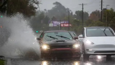 Un automóvil circula por una carretera inundada en el bulevar La Cienega el 24 de diciembre de 2025 en Los Ángeles, California.