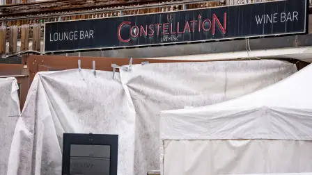 This photograph shows the entrance of the bar Le Constellation where a fire ripped through the venue during New Year's celebrations in the Alpine ski resort town of Crans-Montana killing around 40 people and injuring more than 100 others, in Crans-Montana on January 2, 2026. Investigators raced on January 2, 2026 to identify the victims of a fire that ripped through a bar in the Swiss Alps town of Crans-Montana, turning a New Year's celebration into one of the country's worst tragedies. Frederic Gisler, police commander in the Wallis canton in southwestern Switzerland, told reporters that authorities had counted 
