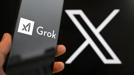 This photograph shows a smartphone bearing the logo of Grok, a generative artificial intelligence chatbot developed by US artificial intelligence company xAI in front of the X (formerly Twitter) logo in Brussels on January 12, 2026. (Photo by Nicolas TUCAT / AFP)