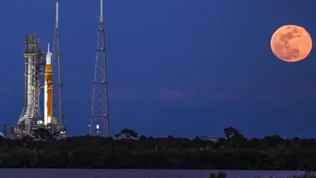 A full moon rises as the Space Launch System (SLS) rocket and the Orion spacecraft, integrated for the Artemis II mission, are seen at Launch Pad 39B at the Kennedy Space Center in Cape Canaveral, Florida, on February 1, 2026 ahead of the first crewed mission to the Moon in more than 50 years. (Photo by Miguel J. Rodriguez Carrillo / AFP)