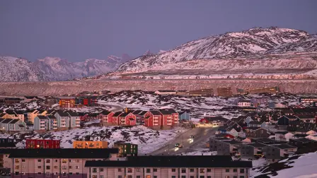 A photo shows a residential area near the airport at the city of Nuuk, western Greenland, with a slightly snow covered mountain in the background, on January 28, 2026. (Photo by Ina FASSBENDER / AFP)