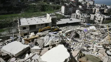 A damaged excavator sits on the rubble of a building that was hit in January by an Israeli strike in the southern Lebanese village of Qannarit, on February 16, 2026. Despite a November 2024 truce that sought to end more than a year of hostilities between Israel and Hezbollah, Israel has kept up regular strikes on Lebanon, usually saying it is targeting the Iran-backed group. (Photo by Joseph EID / AFP)