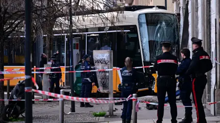 Italian police officers stand at the site of a tram derailment in Milan on February 27, 2026. A tram derailed and smashed into a building in Milan on February 27, 2026, killing one person and injuring around 20 others, the police told AFP. (Photo by Piero CRUCIATTI / AFP)