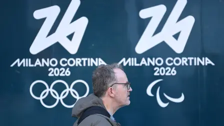 Un hombre pasa junto al logo de los Juegos Olímpicos y Paralímpicos Milán-Cortina 2026 en Milán.