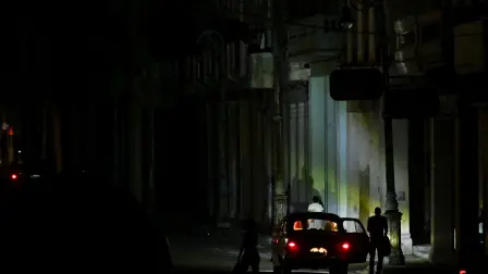 A car parks on a dark street during a blackout in Havana on March 4, 2026. (Photo by Yamil LAGE / AFP)
