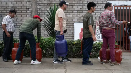 People queue to buy liquefied petroleum gas at a store selling it at the regular price despite rising gas costs in the Chorrillos district of Lima on March 12, 2026. The Peruvian public prosecutor's office launched an investigation on March 4, 2026, into the Gas Transport Company of Peru (TGP) for the crimes of environmental pollution and endangering public health, following a gas leak followed by an explosion in a pipeline at the country's main gas field. (Photo by ERNESTO BENAVIDES / AFP)