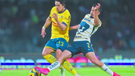 Los jugadores Alan Cervantes de las Águilas y Pablo Bennevendo de los Universitarios disputan una pelota durante el partido de fútbol Pumas vs América correspondiente a la jornada 8 del Torneo Clausura 2025 de Liga BBVA MX, en el Estadio Olímpico Universitario.