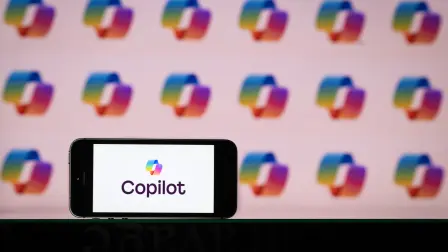 This photograph shows the logo of Microsoft conversational and AI-powered assistant, Copilot, on a phone and a screen, in Mulhouse on October 28, 2025. (Photo by SEBASTIEN BOZON / AFP)