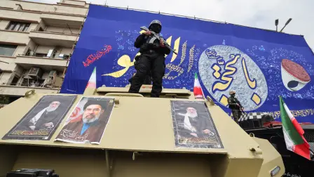 Members of the security forces stand guard on armoured vehicles plastered with portraits of Irans slain supreme leader Ayatollah Ali Khamenei (L and R) and of his son, Iran's new supreme leader Ayatollah Mojtaba Khamenei, during the funerals of Iran's Revolutionary Guards Corps (IRGC) commanders, army commanders and others killed in the early days of the United States and Israeli strikes on Iran, at Enghelab Square in Tehran on March 11, 2026. Washington launched strikes with Israel on Iran on February 28, sparking retaliatory strikes by Tehran against Israel and US bases across the Gulf region. (Photo by Atta KENARE / AFP) / Attention editors: Photo taken with approval from the Ministry of Culture and Islamic Guidance (Ershad) --AFP covers the war in the Middle East through its extensive regional network, including bureaus in Tehran, Jerusalem, and several neighboring countries. Since the start of the conflict, journalists have been working under increasingly restrictive conditions. Authorities in several countries have limited reporters' movements, photo and live video coverage from sensitive locations. Some governments and armed groups have banned images of missile or drone strikes and other security-related sites. /