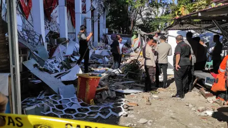 Police officers look at a building of the North Sumatra's National Sports Committee of Indonesia (KONI) damaged following a severe 7.4-magnitude offshore quake in Manado, North Sulawesi on April 2, 2026. (Photo by Tonny Rarung / AFP)