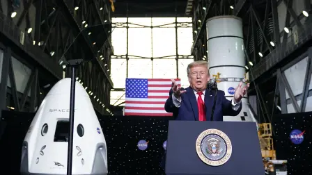 US President Donald Trump speaks near a SpaceX Crew Dragon capsule at a press briefing after the launch of the SpaceX Falcon 9 rocket and Crew Dragon spacecraft on NASA's SpaceX Demo-2 mission to the International Space Station from NASA's Kennedy Space Center in Cape Canaveral, Florida on May 30, 2020. Trump travels to Kennedy Space Center in Florida to watch the launch of the (Photo by MANDEL NGAN / AFP)