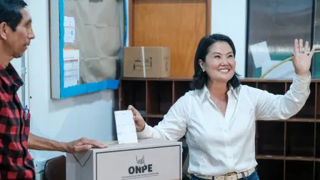 La candidata presidencial peruana Keiko Fujimori saluda mientras emite su voto en un colegio electoral