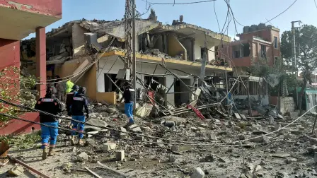 Los servicios de emergencia se congregan en el lugar donde un ataque aéreo israelí tuvo como objetivo un barrio de la aldea de Kfar Roummane, en el sur del Líbano, el 13 de abril de 2026.