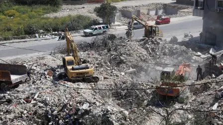 Rescue teams work to remove rubble from a building previously hit by the Israeli army, in the southern Lebanese village of Hanaouay on April 22, 2026. Israel and Lebanon, which have no diplomatic relations, will hold fresh talks in Washington on April 23, 2026, a State Department official told AFP. Israel conducted huge airstrikes across Lebanon and invaded the south after Hezbollah entered the Middle East war in support of its backer Iran on March 2. (Photo by Kawnat HAJU / AFP)
