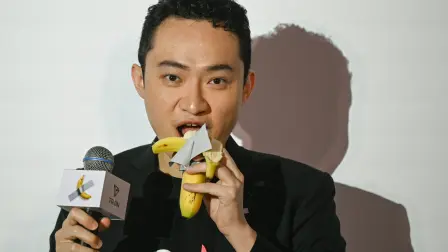 Chinese-born crypto founder Justin Sun eats a banana artwork composed of a fresh banana stuck to a wall with duct tape, in Hong Kong on November 29, 2024, after buying the provocative work of conceptual art by Italian artist Maurizio Cattelan at a New York auction for $6.2 million. The debut of the edible creation entitled "Comedian" at the Art Basel show in Miami Beach in 2019 sparked controversy and raised questions about whether it should be considered art -- Cattelan's stated aim. (Photo by Peter PARKS / AFP)